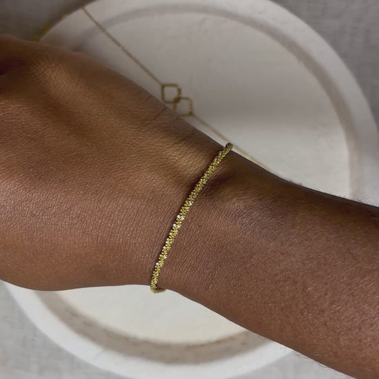 Bracelet doré en acier inoxydable porté au poignet – Gabriela