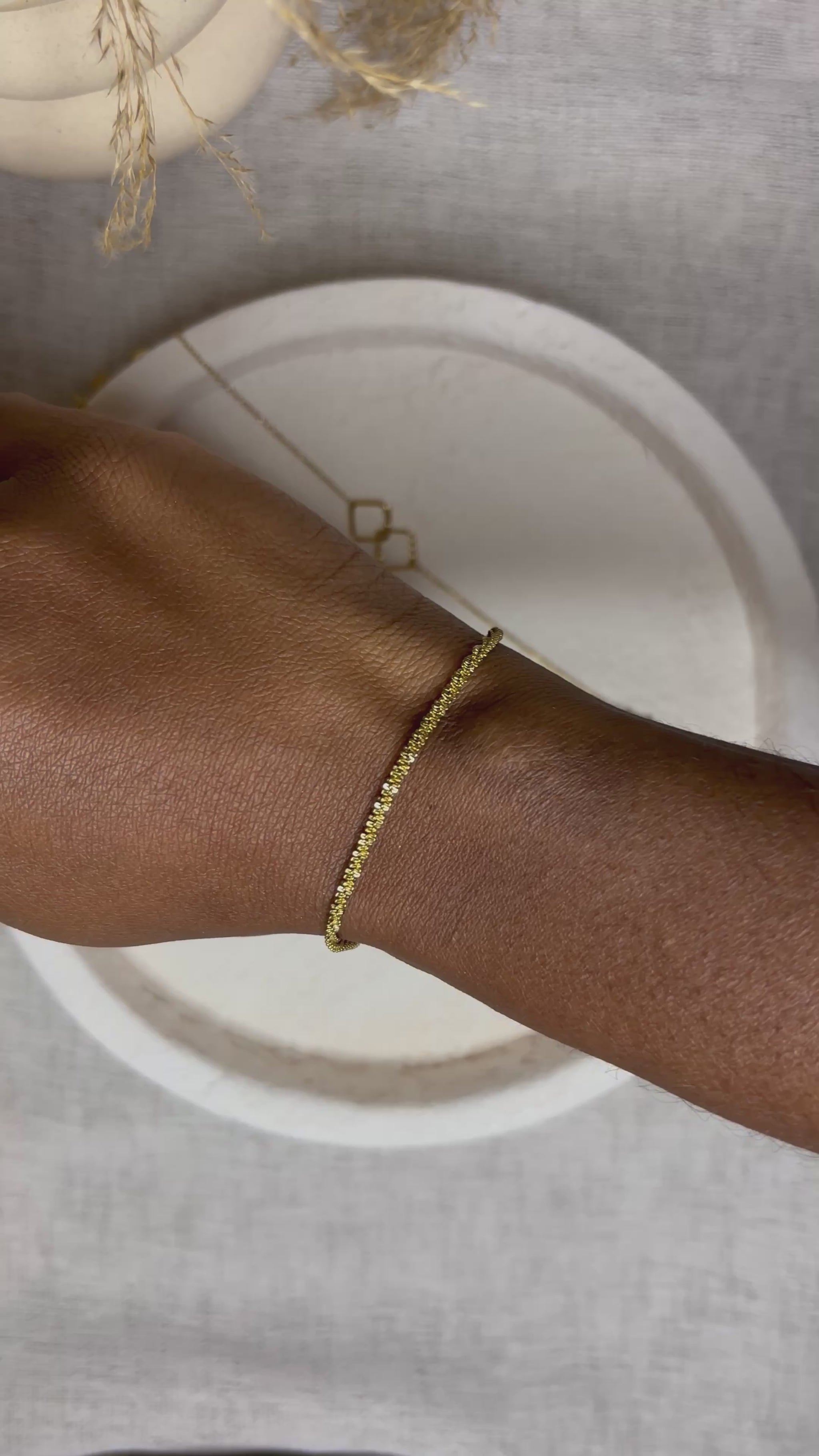 Bracelet doré en acier inoxydable porté au poignet – Gabriela