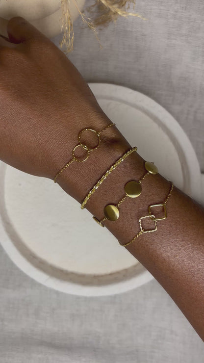 Bracelets dorés en acier inoxydable Gabriela portés au poignet - design minimaliste et élégant 